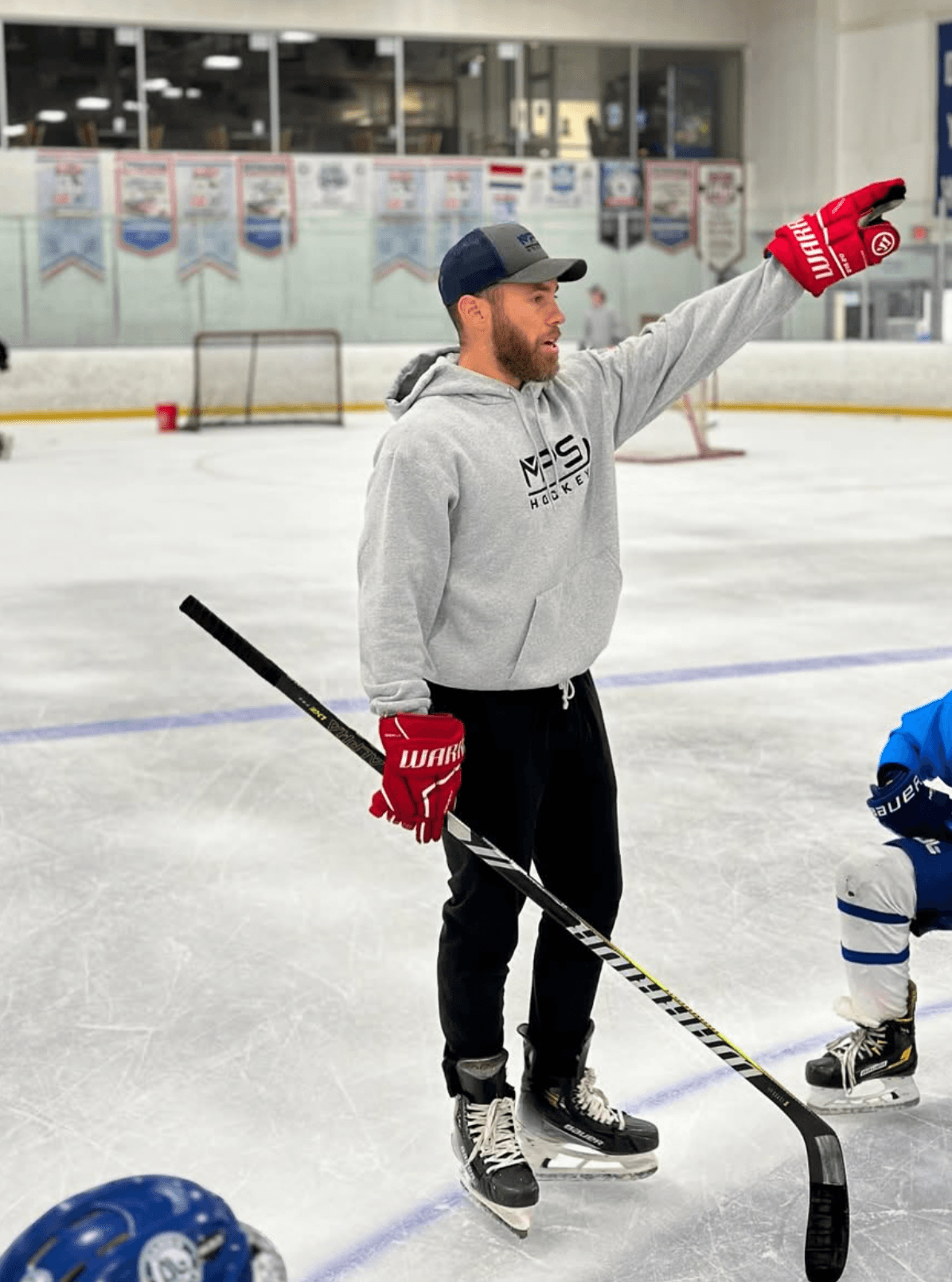 Coach Seth leading a training session on the ice.